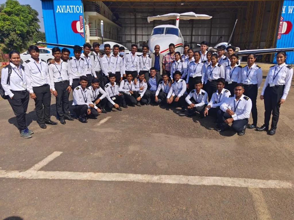 Group photo outside hangar with aircraft